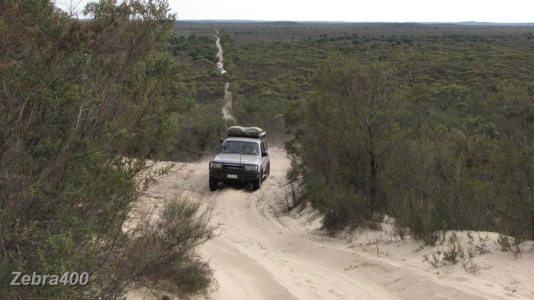 21-Manky spins the wheels heading up a dune on the Border Track.JPG
